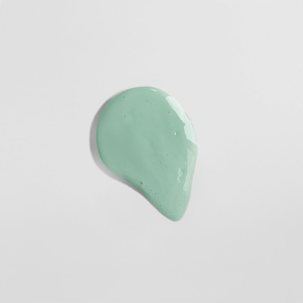 Ein tropfenförmiger Klecks hellgrüner Flüssigkeit auf einem weißen Hintergrund.