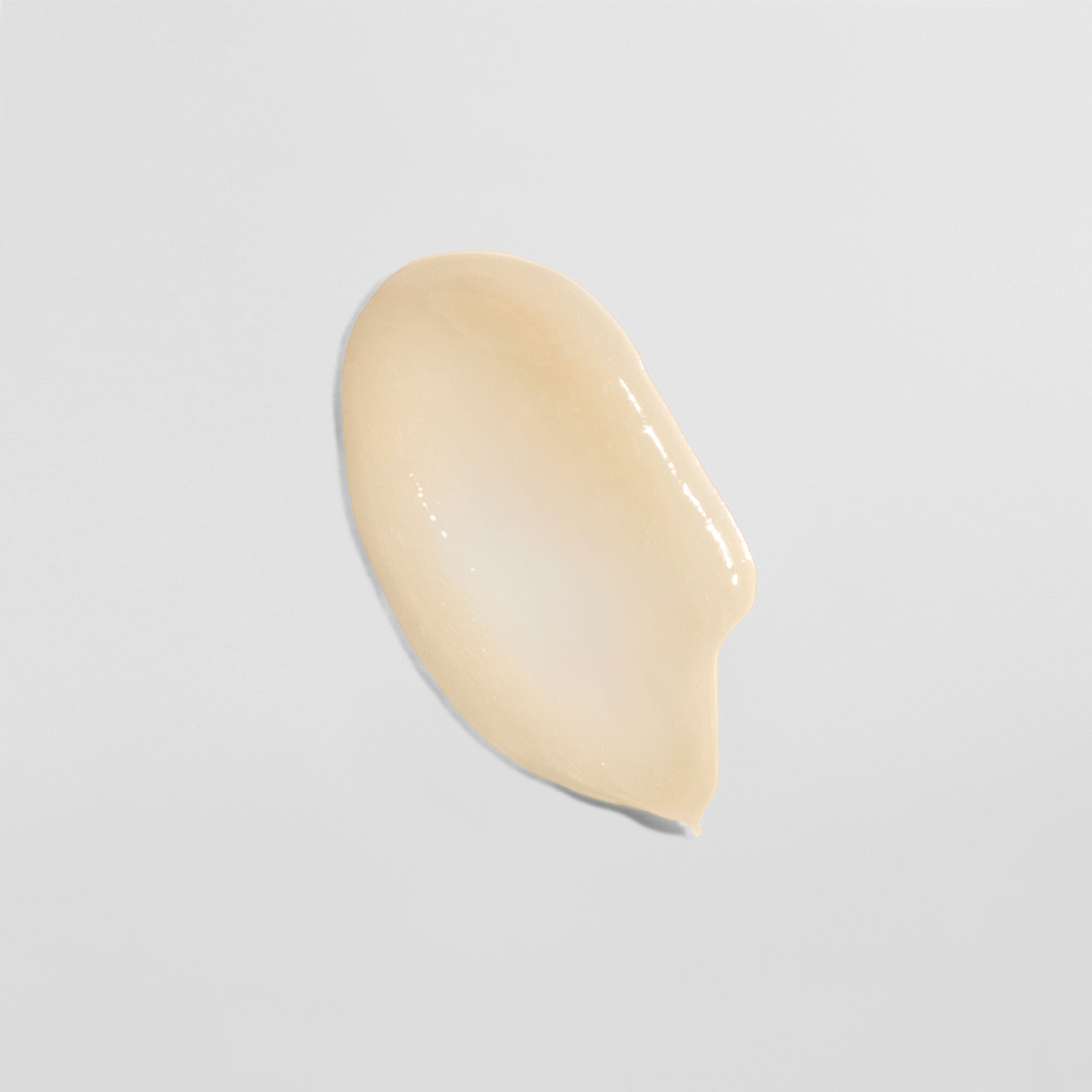 Beige Cremetropfen auf weißem Hintergrund.