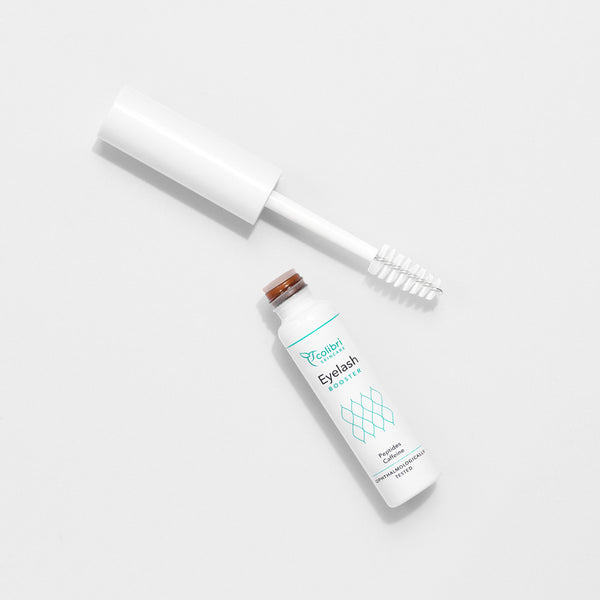 Weiße Tube eines Wimpernserums mit geöffnetem Deckel auf einem weißen Hintergrund.